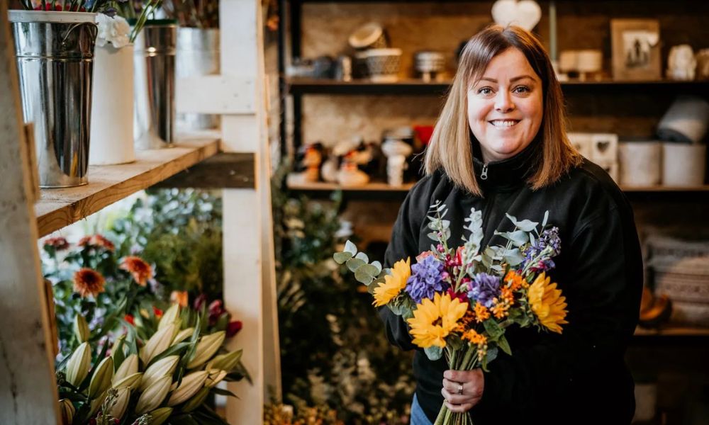 Rachel Jenkins standing in The Dancing Daffodil shop with bouquet of flowers in her hand