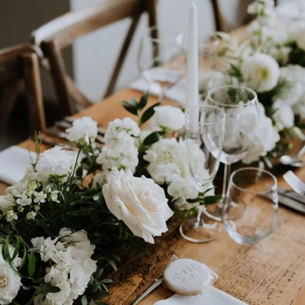 Image of white roses and flowers being used in the centre of the tables